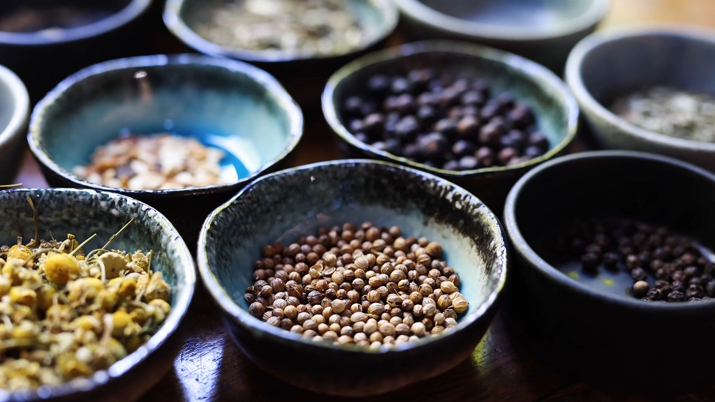 Mixing ingredients to create unique gin flavors in a batch