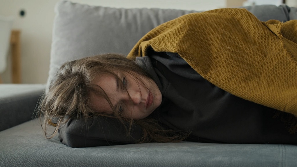 A woman lying on the bed with stomach problems