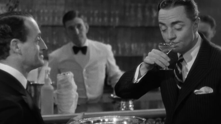 A black-and-white image of two men, one drinking from a cocktail glass while a bartender stands in the background