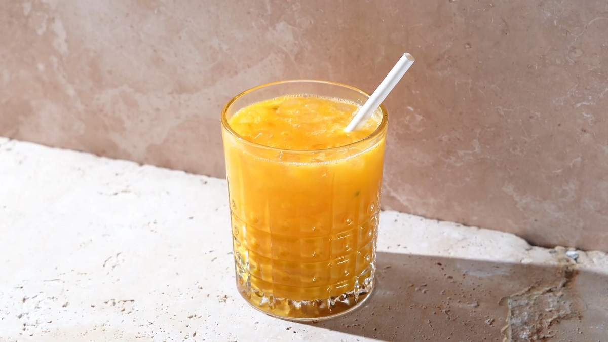 A tropical mango Mocktail in a textured glass with a straw