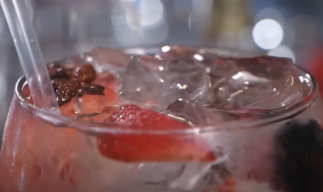 Refreshing gin and tonic garnished with strawberries and spices