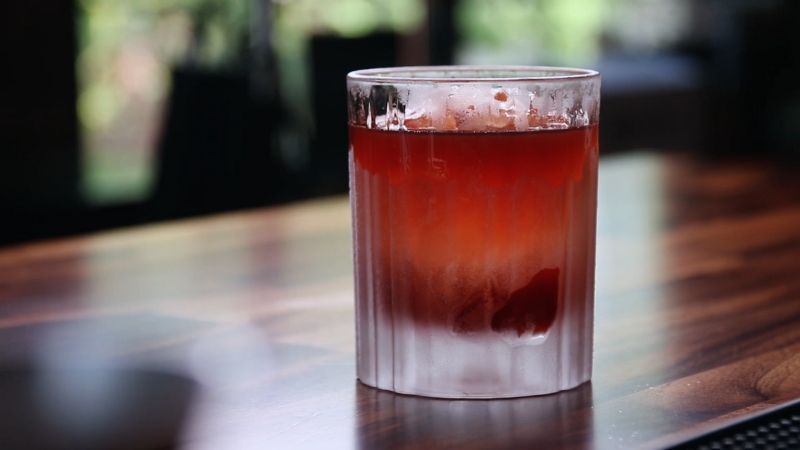 A Chilled Glass of Coffee Negroni Sits on A Wooden Bar Counter