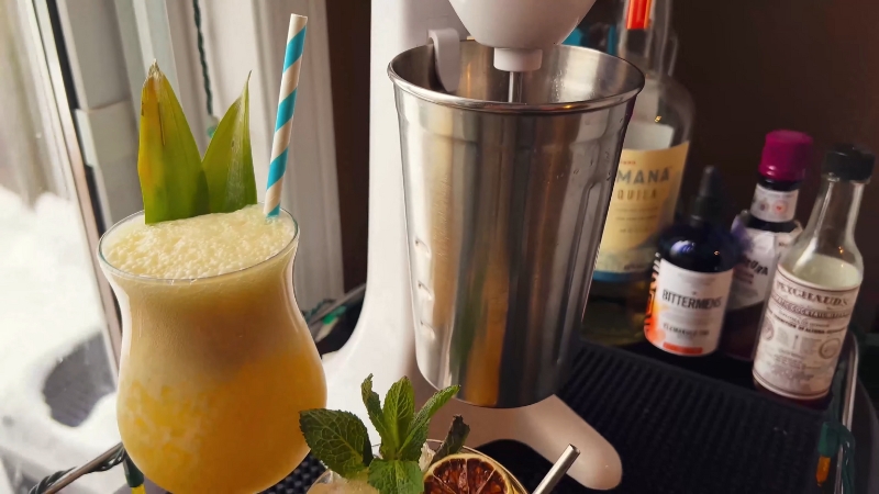 An Electric Stirrer Is Placed Next to Two Cocktails