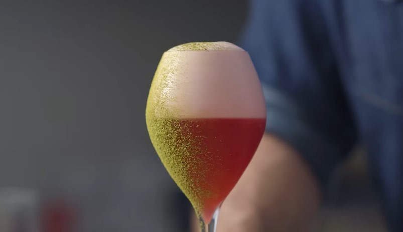 A vibrant, ruby-red cocktail, topped with a delicate layer of frothy