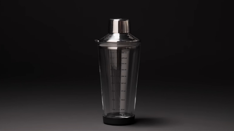 A Close-Up Image of A Glass Cocktail Shaker with Measurement Markings on A Dark Background